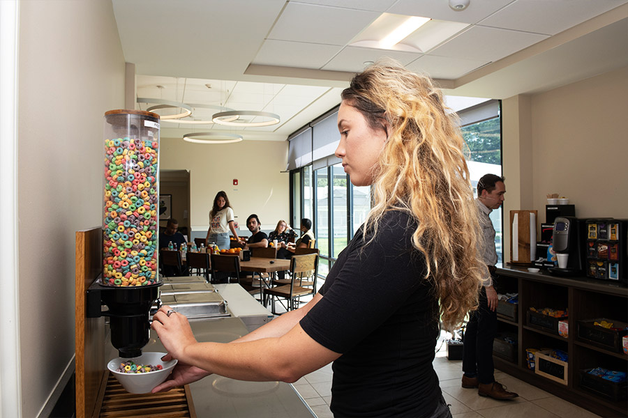 a woman getting some cereal at dining room